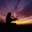 “Evening Song.” “While photographing Charlie Pratt's life size sculpture, a spectacular sunset appeared. Charlie sat on a rock and began to play his flute; a photograph I couldn't resist.” J.J.